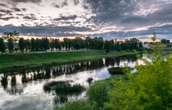 Cielo drammatico di tramonto sopra il fiume di Tvertsa e le sue rive pittoresche dopo la tempesta Città provinciale russa Toržok, Immagine Stock Libera da Diritti Cielo drammatico di tramonto sopra il fiume di Tvertsa e le sue rive pittoresche dopo la tempesta Città provinciale russa Toržok, Immagine Stock Libera da Diritti