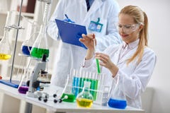 Científico de sexo femenino sonriente que usa el líquido de la química para la investigación imagen de archivo Científico de sexo femenino sonriente que usa el líquido de la química para la investigación imagen de archivo