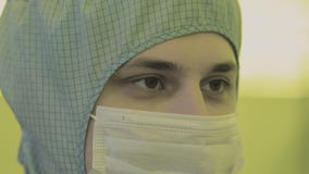 Científico en trajes estéril, máscara del ingeniero esté en una zona limpia que mira un proceso avanzó tecnológico la fábrica Científico en trajes estéril, máscara del ingeniero esté en una zona limpia que mira un proceso avanzó tecnológico la fábrica