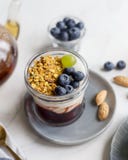 Cierre encima del granola con el atasco, la crema y las bayas en tarro foto de archivo Cierre encima del granola con el atasco, la crema y las bayas en tarro foto de archivo