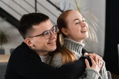 Cierre encima del retrato principal del tiro del hombre joven y de la mujer felices sonrientes que abrazan y que miran lejos Cari foto de archivo Cierre encima del retrato principal del tiro del hombre joven y de la mujer felices sonrientes que abrazan y que miran lejos Cari foto de archivo