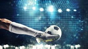 Cierre para arriba de un delantero del fútbol listo a los retrocesos la bola en la meta del fútbol imágenes de archivo libres de regalías Cierre para arriba de un delantero del fútbol listo a los retrocesos la bola en la meta del fútbol imágenes de archivo libres de regalías