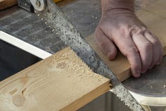 Cieśla ręka z starym handsaw ciie drewniane deski obrazy stock Cieśla ręka z starym handsaw ciie drewniane deski obrazy stock
