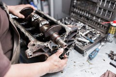 Cigüeñal del motor, cubierta de la válvula, pistones Reparador del mecánico en el trabajo de la reparación del mantenimiento del Fotografía de archivo libre de regalías Cigüeñal del motor, cubierta de la válvula, pistones Reparador del mecánico en el trabajo de la reparación del mantenimiento del Fotografía de archivo libre de regalías