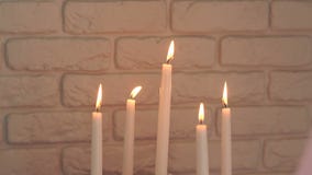 Cinco velas ardientes contra la pared de ladrillo Cinco velas ardientes contra la pared de ladrillo