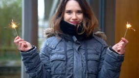 Cinemagraph женщины снаружи в холоде держа 2 бенгальского огня Cinemagraph женщины снаружи в холоде держа 2 бенгальского огня