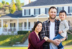 Cinese della corsa mista e genitori e bambino del Caucasian in Front Yard fotografia stock Cinese della corsa mista e genitori e bambino del Caucasian in Front Yard fotografia stock