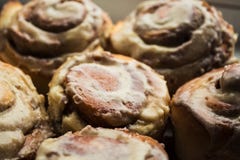 Cinnabon roule avec le lustre de fromage fondu sur le plat photos libres de droits Cinnabon roule avec le lustre de fromage fondu sur le plat photos libres de droits