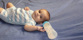 Cinq mois de bébé garçon jouant sur le lit photos libres de droits Cinq mois de bébé garçon jouant sur le lit photos libres de droits
