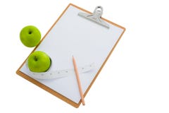 Cinta métrica envuelta alrededor de una manzana y de un tablero verdes Imagen de archivo Cinta métrica envuelta alrededor de una manzana y de un tablero verdes Imagen de archivo