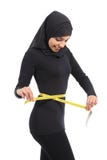 Cintura de medición de la mujer árabe con una cinta de la medida imágenes de archivo libres de regalías Cintura de medición de la mujer árabe con una cinta de la medida imágenes de archivo libres de regalías