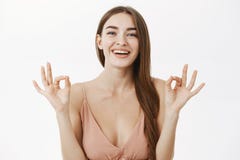 Cintura-para arriba tirada de hembra magnífica europea feliz optimista en la autorización beige de moda de la demostración del ve fotografía de archivo libre de regalías Cintura-para arriba tirada de hembra magnífica europea feliz optimista en la autorización beige de moda de la demostración del ve fotografía de archivo libre de regalías