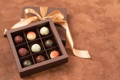 Cioccolato fine in scatola del mestiere con il nastro del raso su un fondo scuro Posto per progettazione Disposizione piana Conce fotografia stock Cioccolato fine in scatola del mestiere con il nastro del raso su un fondo scuro Posto per progettazione Disposizione piana Conce fotografia stock