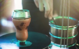Ciotola del narghil? con carbone per il primo piano di fumo Passa la tenuta del forcipe per il narghil? di shisha e regola i carb fotografia stock Ciotola del narghil? con carbone per il primo piano di fumo Passa la tenuta del forcipe per il narghil? di shisha e regola i carb fotografia stock