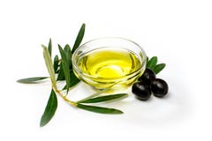 Ciotola di vetro con olio d'oliva, olive nere e le foglie Primo piano, isolato su fondo bianco fotografia stock libera da diritti Ciotola di vetro con olio d'oliva, olive nere e le foglie Primo piano, isolato su fondo bianco fotografia stock libera da diritti