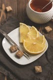 Citronskivor, farin och en kopp te på en trälantlig tabell Selektivt fokusera tonat fotografering för bildbyråer Citronskivor, farin och en kopp te på en trälantlig tabell Selektivt fokusera tonat fotografering för bildbyråer