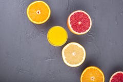 Citrus fruits with assorted slices and juice in a glass. Gray stone background. Vitamins and health in food. Copy space royalty free stock photography Citrus fruits with assorted slices and juice in a glass. Gray stone background. Vitamins and health in food. Copy space royalty free stock photography