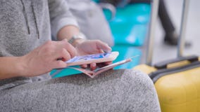Ciérrese encima de tiro de las manos del ` un s de la mujer que sostienen smartphone y el pasaporte en un terminal almacen de metraje de vídeo Ciérrese encima de tiro de las manos del ` un s de la mujer que sostienen smartphone y el pasaporte en un terminal almacen de metraje de vídeo