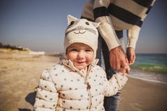 Ciérrese encima del retrato del pequeño niño sonriente que celebra la mano del ` s de la madre al aire libre en el océano, mirand imágenes de archivo libres de regalías Ciérrese encima del retrato del pequeño niño sonriente que celebra la mano del ` s de la madre al aire libre en el océano, mirand imágenes de archivo libres de regalías