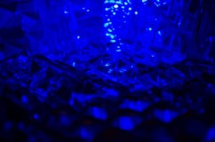 Ciérrese para arriba de cristal cortado en luz azul misteriosa imágenes de archivo libres de regalías Ciérrese para arriba de cristal cortado en luz azul misteriosa imágenes de archivo libres de regalías