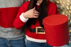 Ciérrese para arriba de gente joven en los suéteres que sostienen los regalos fotografía de archivo Ciérrese para arriba de gente joven en los suéteres que sostienen los regalos fotografía de archivo