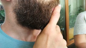 Ciérrese para arriba de hombre habla y piensa frotando ligeramente su barba almacen de video Ciérrese para arriba de hombre habla y piensa frotando ligeramente su barba almacen de video