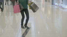 Ciérrese para arriba de la mujer feliz divertida en los talones que llevan los panieres que camina de una manera de la moda que h almacen de video Ciérrese para arriba de la mujer feliz divertida en los talones que llevan los panieres que camina de una manera de la moda que h almacen de video