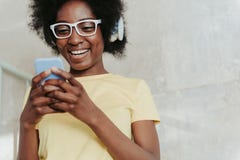 Ciérrese para arriba de llevar africano de la señora casual y de mantener el teléfono móvil brazos fotos de archivo Ciérrese para arriba de llevar africano de la señora casual y de mantener el teléfono móvil brazos fotos de archivo