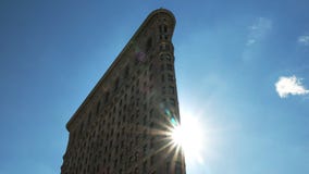 Ciérrese para arriba del sol detrás del edificio de la plancha Ciérrese para arriba del sol detrás del edificio de la plancha