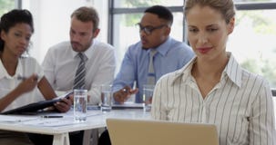Ciérrese para arriba en una empresaria que sonríe y que usa un ordenador portátil almacen de metraje de vídeo Ciérrese para arriba en una empresaria que sonríe y que usa un ordenador portátil almacen de metraje de vídeo