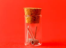 Clapton fuso si arrotola per i dispositivi vaping moderni in un contenitore di vetro fotografia stock libera da diritti Clapton fuso si arrotola per i dispositivi vaping moderni in un contenitore di vetro fotografia stock libera da diritti