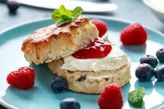 Classic English scones with clotted cream, strawberries jam and other fruit stock photography Classic English scones with clotted cream, strawberries jam and other fruit stock photography