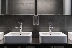 Clean new public toilet room empty. Two sinks and soap tank royalty free stock photos Clean new public toilet room empty. Two sinks and soap tank royalty free stock photos