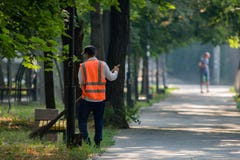 Cleaning Leaves In The City, Janitor Sweeping The Foliage In City Park. A Street Sweeper With Broom, Work Of Housing And Communal Royalty Free Stock Image