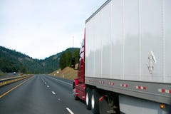 Clear red big rig semi truck white dry van trailer in perspective road sky stock photo Clear red big rig semi truck white dry van trailer in perspective road sky stock photo