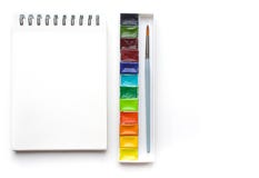 Clear sheet note book and colour watercolor paint on white background.