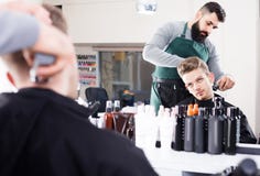 Client feeling discontent about his new haircut at hair salon Stock Image Client feeling discontent about his new haircut at hair salon Stock Image