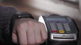 Client payant avec la technologie de NFC par la montre intelligente sans contact sur le terminal en café moderne clips vidéos Client payant avec la technologie de NFC par la montre intelligente sans contact sur le terminal en café moderne clips vidéos