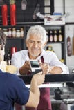 Cliente de Accepting Payment From do vendedor através do cartão de crédito imagem de stock Cliente de Accepting Payment From do vendedor através do cartão de crédito imagem de stock