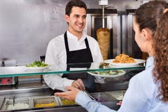 Cliente masculino de sorriso do serviço do trabalhador com sorriso no plac do shawarma fotos de stock Cliente masculino de sorriso do serviço do trabalhador com sorriso no plac do shawarma fotos de stock