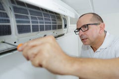 Climatisation focalisée d'essai de bricoleur sur le mur image libre de droits Climatisation focalisée d'essai de bricoleur sur le mur image libre de droits