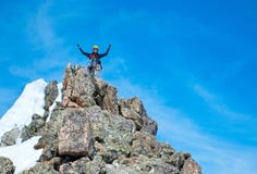 Climber reaches the summit of mountain peak. Success, freedom and happiness, achievement in mountains. Climbing sport concept. royalty free stock photography Climber reaches the summit of mountain peak. Success, freedom and happiness, achievement in mountains. Climbing sport concept. royalty free stock photography
