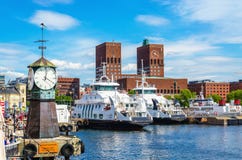 Clock on Aker Brygge, modern and Oslo City Hall royalty free stock photo Clock on Aker Brygge, modern and Oslo City Hall royalty free stock photo