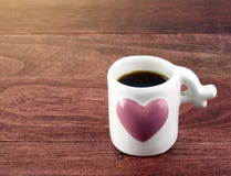 Close-up black coffee in small white coffee cup with big pink heart on dark brown wooden table floor with morning sunlight stock photos Close-up black coffee in small white coffee cup with big pink heart on dark brown wooden table floor with morning sunlight stock photos
