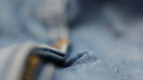 Close up blue jeans pants with zip and metal button. Fabric textile texture
