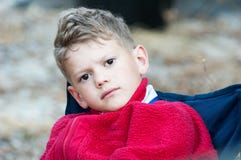 Close-up of a boy in a red fleece on a blue chair stock photography Close-up of a boy in a red fleece on a blue chair stock photography