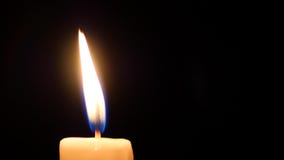 Close-up of a candle flame on black background.