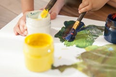 Close-up of cans with paints, brushes and children`s hands. stock photo Close-up of cans with paints, brushes and children`s hands. stock photo