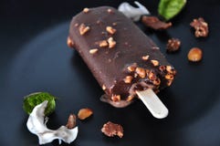 Close up Chocolate Ice Cream Bar melting on Black Plate stock photos Close up Chocolate Ice Cream Bar melting on Black Plate stock photos