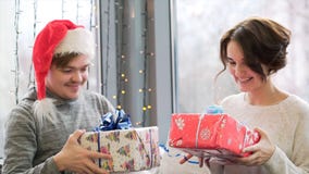 Close up for couple exchanging gifts while celebrating Christmas and New Year together. Man in Santa Claus hat and woman stock photography Close up for couple exchanging gifts while celebrating Christmas and New Year together. Man in Santa Claus hat and woman stock photography